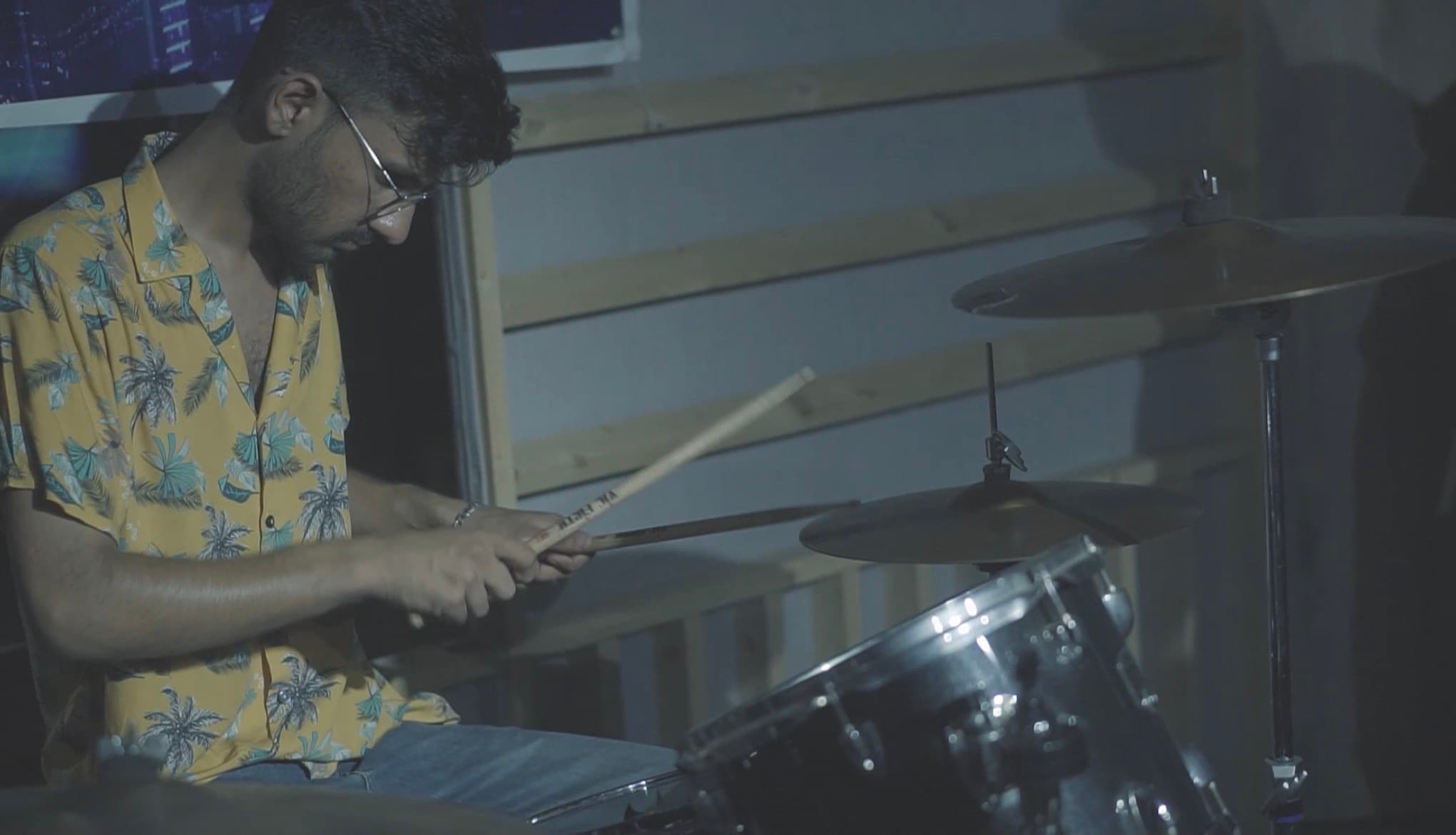 A drummer playing in a rehearsal space